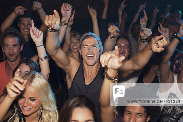 Enthusiastic man cheering in crowd at concert