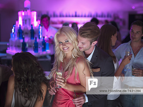 Porträt eines lächelnden Paares mit Cocktails im Nachtclub
