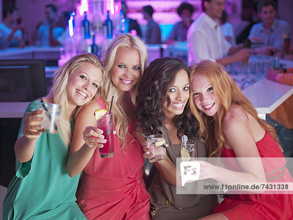 Porträt von lächelnden Frauen mit Cocktails im Nachtclub