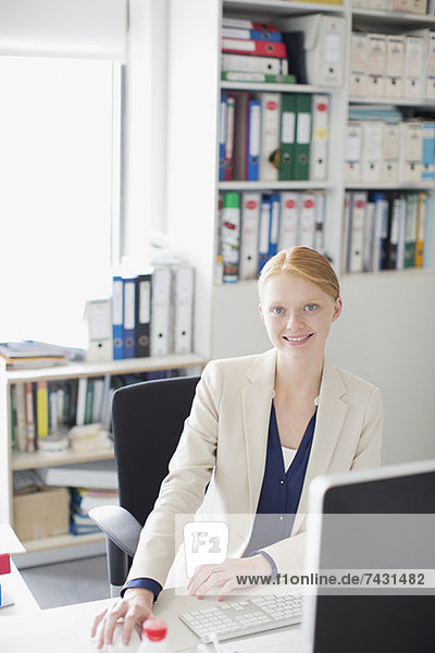Portrait of smiling businesswoman at desk in office