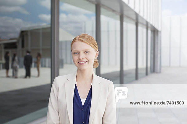 Porträt einer lächelnden Geschäftsfrau vor dem Gebäude