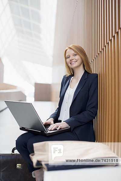 Portrait of smiling businesswoman using laptop