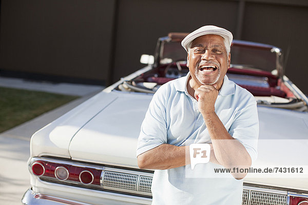 Älterer Mann lächelt mit Cabriolet