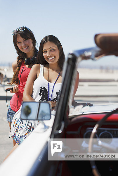 Lächelnde Frauen beim Cabriolet
