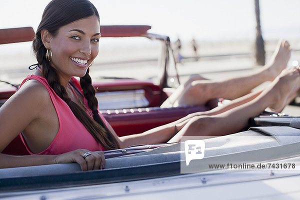 Lächelnde Frau entspannt im Cabriolet