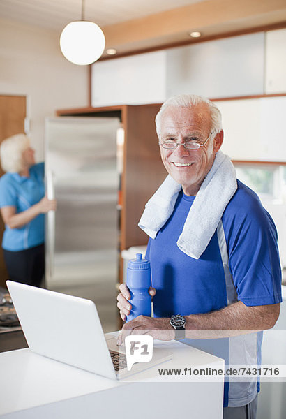 Älterer Mann mit Laptop nach dem Training