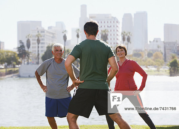 Ältere Paare trainieren mit Trainer im Park