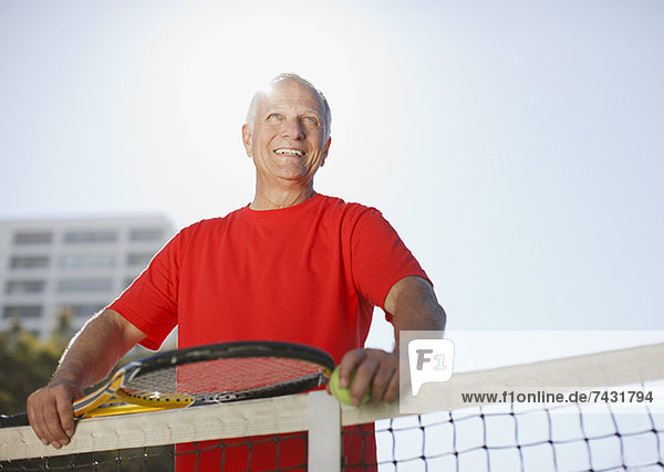 Älterer Mann beim Tennisspielen auf dem Platz