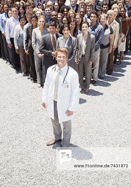 Porträt eines selbstbewussten Arztes mit Geschäftsleuten im Hintergrund