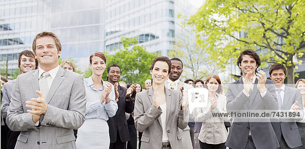 Portrait of clapping business people in crowd