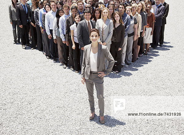 Porträt einer selbstbewussten Geschäftsfrau mit einem Team von Geschäftsleuten im Hintergrund