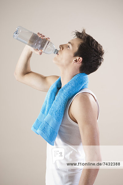 junger Mann trinkt aus einer Wasserflasche