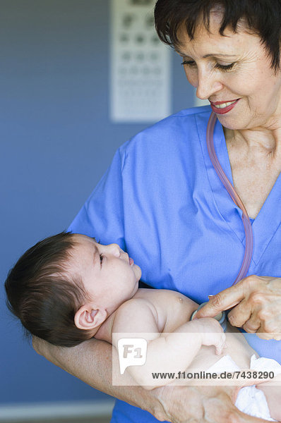 Nurse holding baby in doctor's office