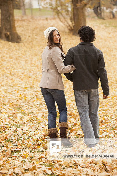 Couple walking in autumn leaves