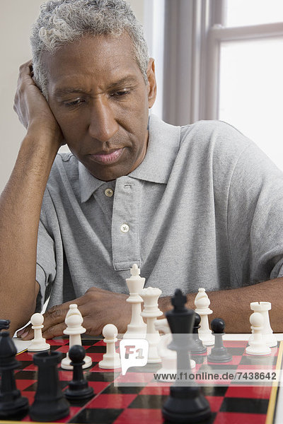 Mixed race man playing chess