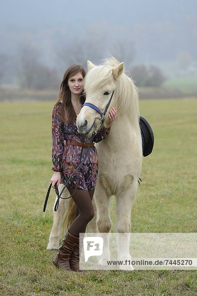 Lächelnde junge Frau mit einem Pferd