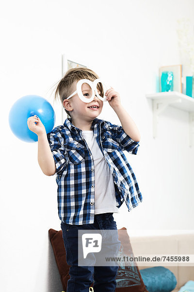 Junge mit Luftballon und Partybrille