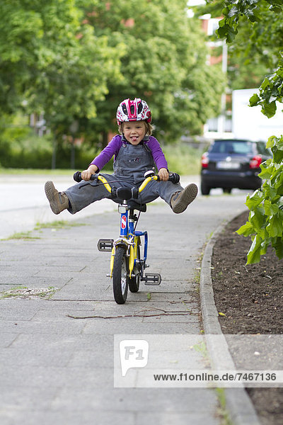 Übermütiges Kleinkind auf einem Fahrrad