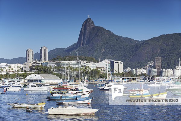 Boats moored in harbour with Christ the Redeemer statue in background  Urca  Rio de Janeiro  Brazil  South America