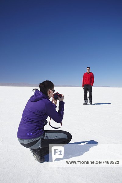 Couple taking photos on Salar de Uyuni (Salt Flats of Uyuni)  Potosi Department  Bolivia  South America