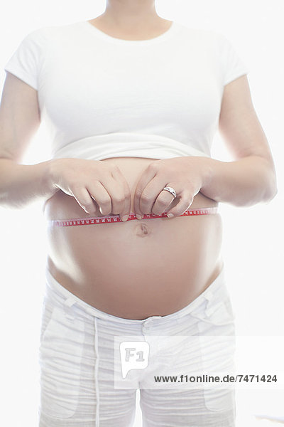Schwangere Frau  die den Bauch misst