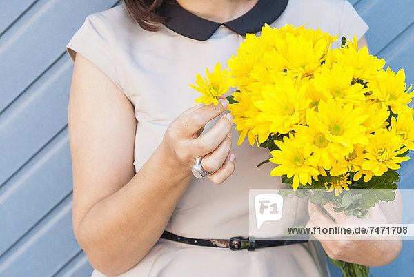 Frau mit gelbem Blumenstrauß