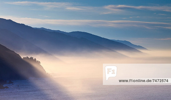 Fog rolling through snowy landscape