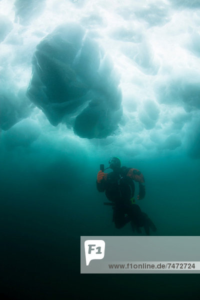 Man scuba diving under glacier
