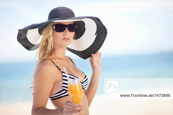 Woman in bikini and floppy hat on beach