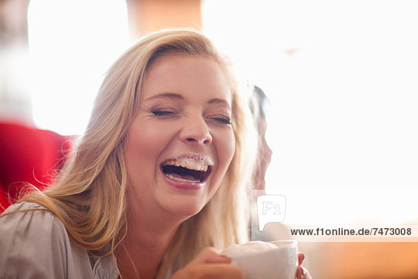 Lachende Frau mit Milchbart