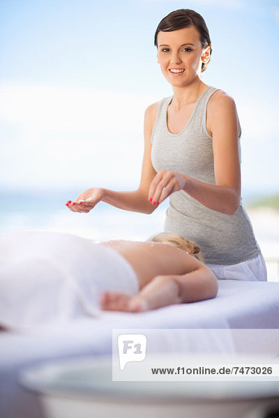 Woman giving massage on beach