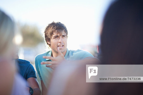 Man talking with friends outdoors