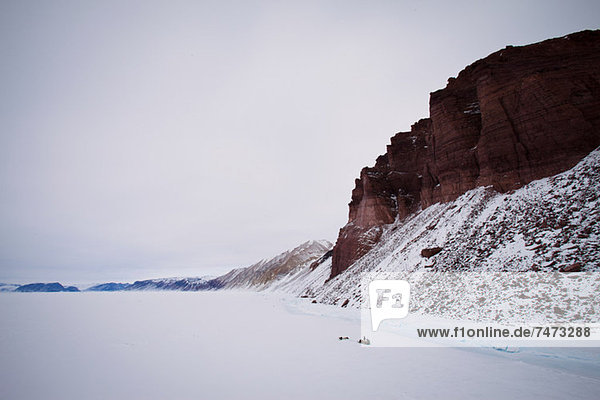 Red cliffs in snowy landscape
