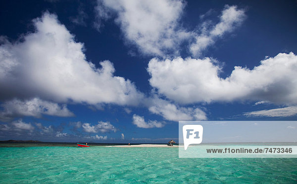 Clouds over sandbar and tropical water
