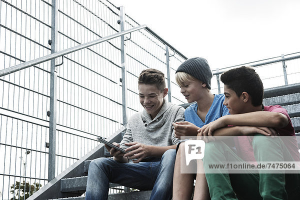 Boys with Tablet Sitting on Bleachers  Mannheim  Baden-Wurttemberg  Germany