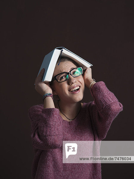 Gesichtsausdruck  Gesichtsausdrücke  Ausdruck  Ausdrücke  Mimik  Portrait  Jugendlicher  Brille  Sorge  Buch  offen  über  halten  Kleidung  Mädchen  Taschenbuch