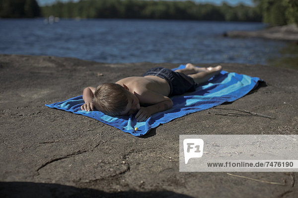 Felsbrocken  liegend  liegen  liegt  liegendes  liegender  liegende  daliegen  Strand  Junge - Person  Handtuch  See  Kanada  Muskoka  Ontario