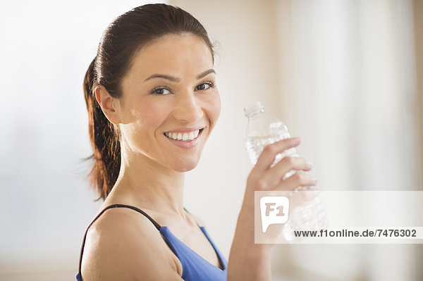 Portrait of woman drinking water in gym