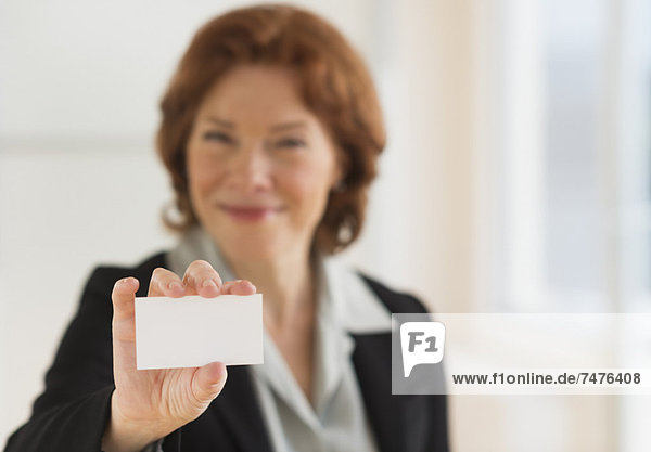 Portrait of businesswoman showing blank business card