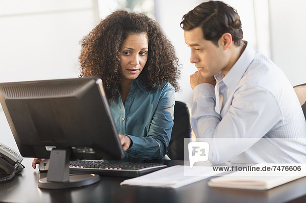 Man and woman working at desk in office