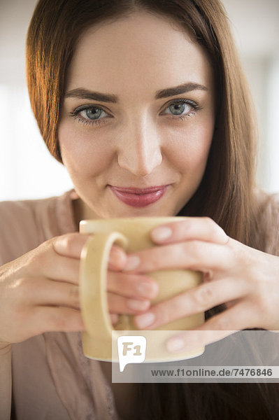 Portrait of junge Frau hält Kaffeetasse