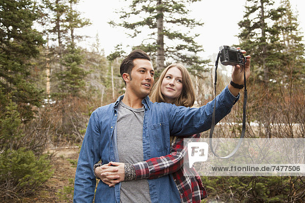 Young couple self photographing in non-urban scene