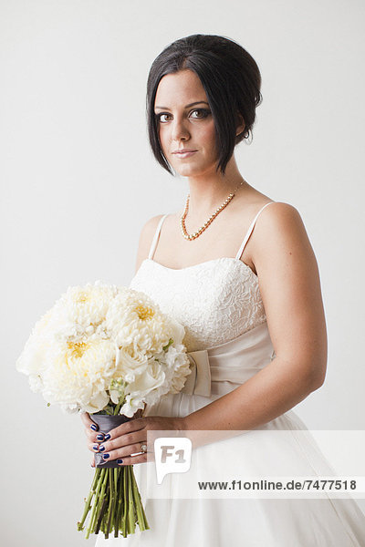Studio Shot portrait of bride holding bouquet
