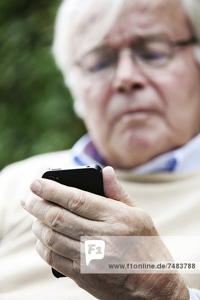 Senior holding a smartphone in his hands