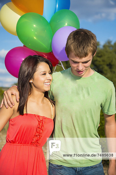 USA  Texas  Teenager Junge und junge Frau mit Luftballons  lächelnd