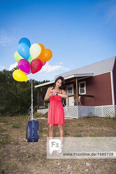 USA  Texas  Junge Frau mit Koffer und Ballons