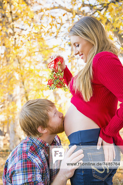 USA  Texas  Mann küsst schwangeren Frauen Bauch  Nahaufnahme