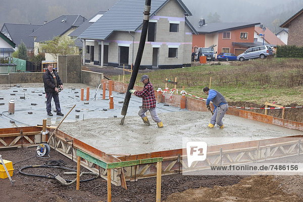 Europa  Deutschland  Rheinland-Pfalz  Bauarbeiter beim Betonieren von Fundamenten und Fernbedienungen