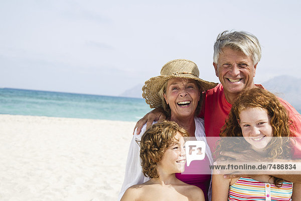 Spanien  Großeltern mit Enkelkindern  die Spaß am Strand haben  lächeln