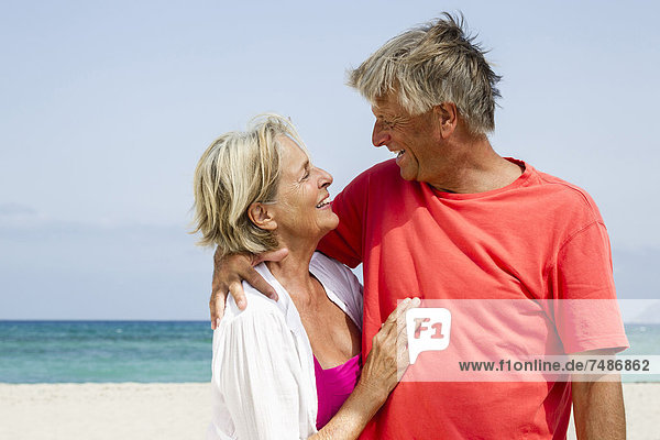 Spanien  Senior Paar Romantik am Strand  lächelnd